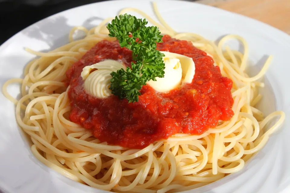 Spaghetti in chunky tomato sauce on a white plate